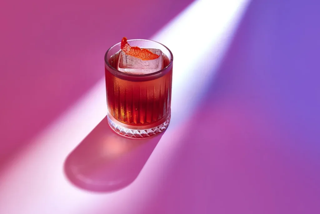 Food-Fotografie Trends 2025: Stilvolle Inszenierung eines Cocktails im Neon-Licht mit dramatischen Farbakzenten, modern umgesetzt von Socialfood.